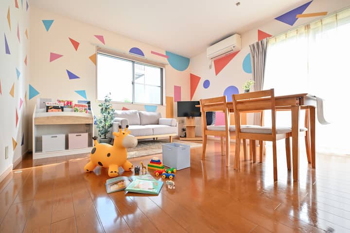 カラフルな壁とおもちゃ・絵本が用意されたキッズフレンドリーなリビング