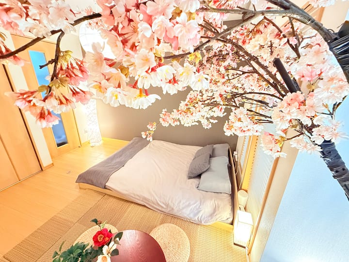 満開の桜のアートに包まれたローベッドの寝室