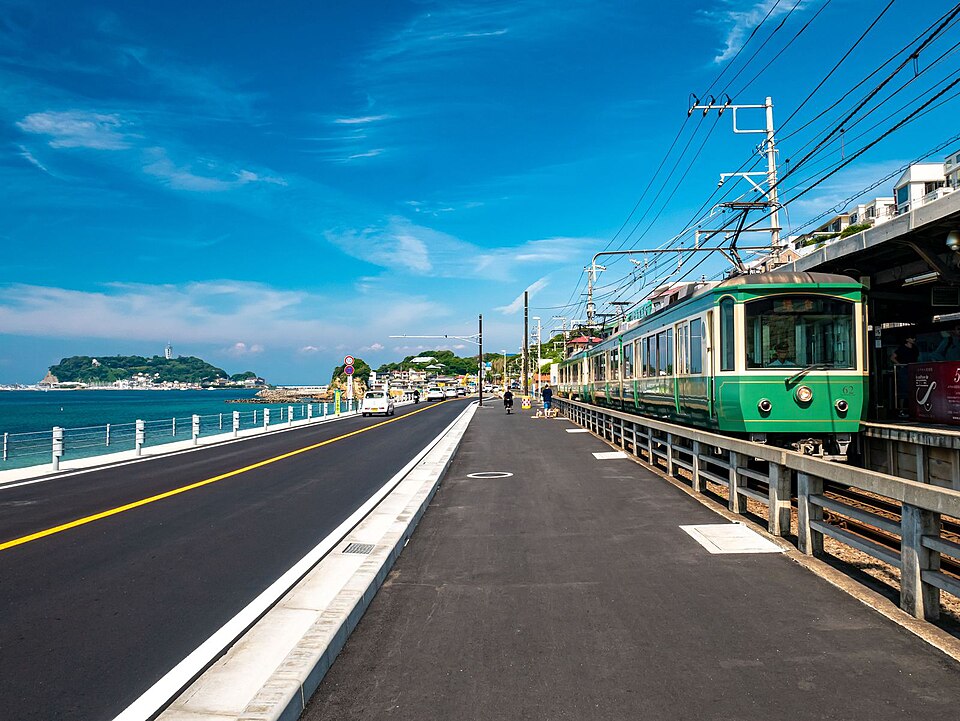 江ノ電と江の島を望む鎌倉高校前駅付近の海沿いの風景