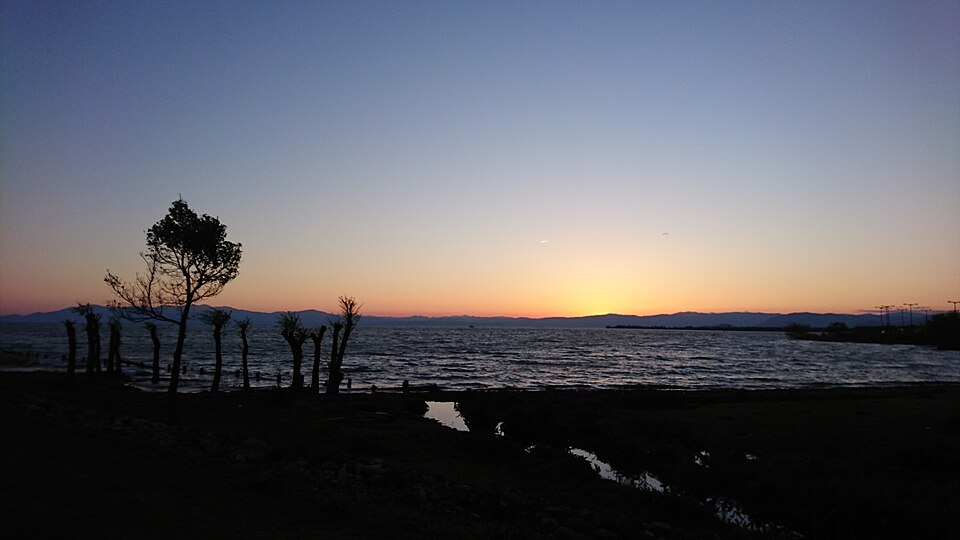 夕暮れの琵琶湖。静かな湖畔に夕日が沈む